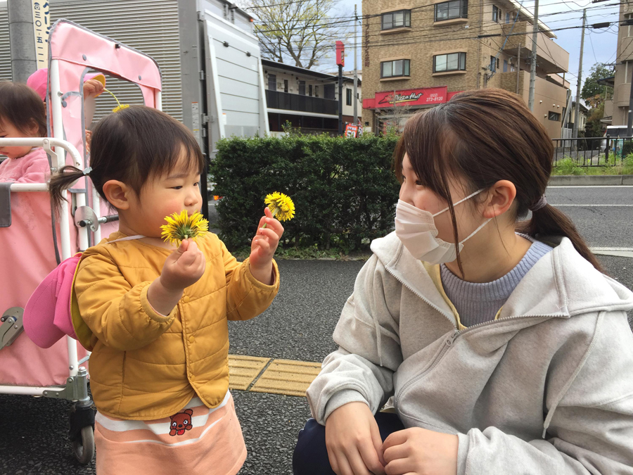 先生とお子さんがたんぽぽを発見して笑顔の写真