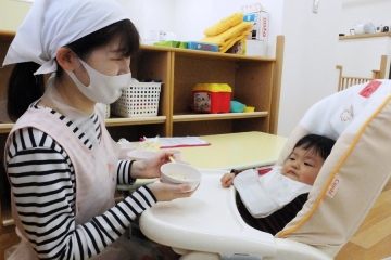 お子さんに先生がご飯をあげている様子