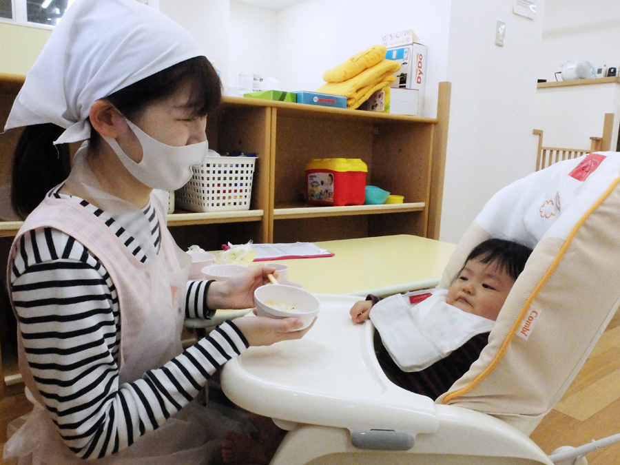 お子さんに先生がご飯をあげている様子
