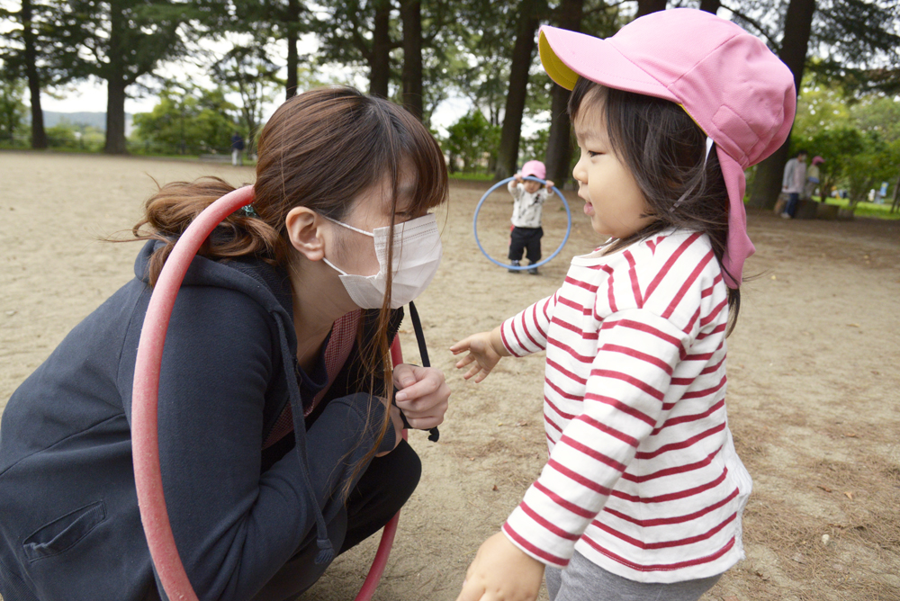 お子さんがフラフープで先生と遊んでいる